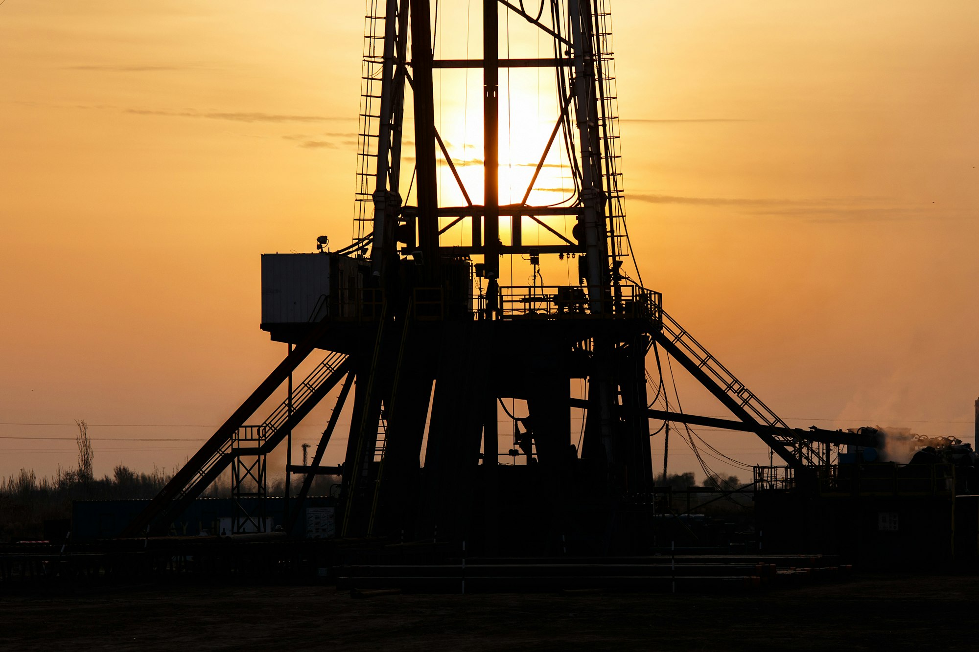 Drilling derrick silhouetted at dusk